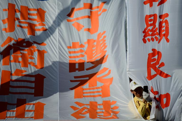 A protester takes a picture between banners during a march for press freedom in Hong Kong on February 23, 2014