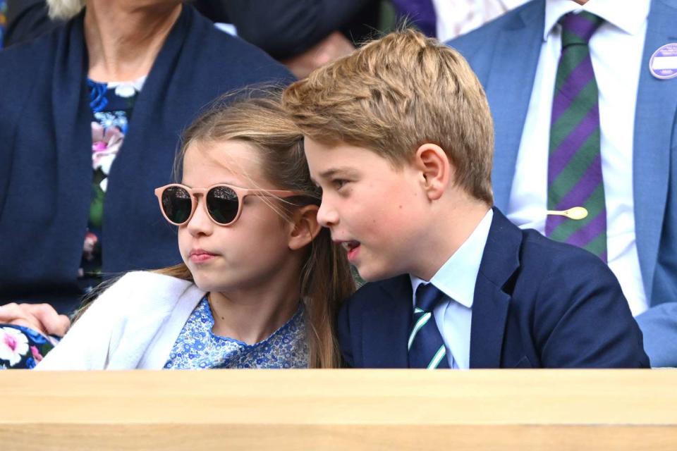 <p>Karwai Tang/WireImage</p> Princess Charlotte and Prince George chat while watching the Wimbledon Tennis Championships on July 16 — the little princess