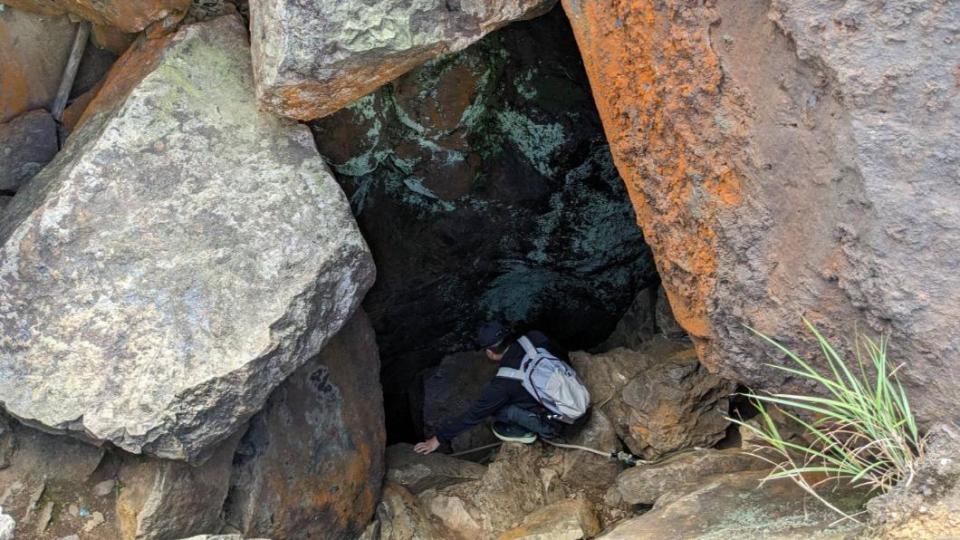 梁姓男子走入山洞內，發現前方是懸崖，想要原路退回，又因有５公尺高度差，無力往上爬。（圖／新北市消防局提供）
