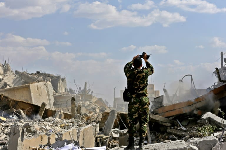 A Syrian soldier inspects the wreckage of a building described as part of the Scientific Studies and Research Centre (SSRC) compound in the Barzeh district north of Damascus, during a press tour organised by the Syrian government after US-led strikes