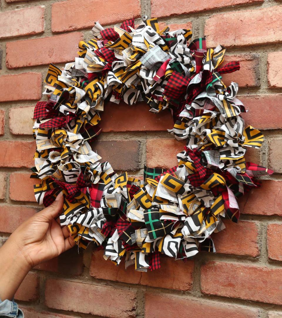 Da'Shika Street with a wreath she created from fabric scraps Monday in Akron. Street has an e-commerce business where she sells clothes and home goods made out of African fabrics.