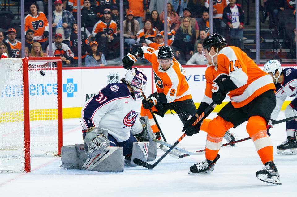 Philadelphia Flyers' Owen Tippett, right, shoots the puck past Columbus Blue Jackets goalie Michael Hutchinson, left, for an overtime goal in an NHL hockey game, Tuesday, April 11, 2023, in Philadelphia. The Flyers won 4-3. (AP Photo/Chris Szagola)