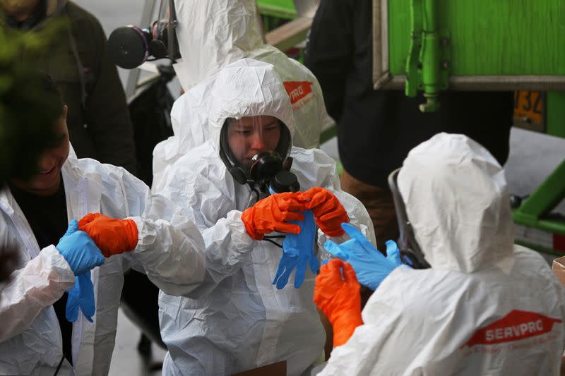 Members of a Servpro cleanup crew wear hazardous material suits as they prepare to enter Life Care Center of Kirkland, the Seattle-area nursing home at the epicenter of one of the biggest coronavirus outbreaks in the United States, in Kirkland