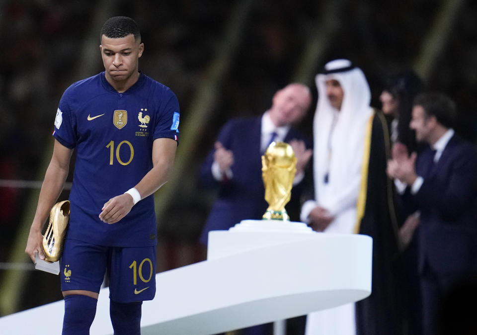 FILE - France's Kylian Mbappe holds the Golden Boot award for top goal scorer of the tournament during the awards ceremony after Argentina defeated France in the World Cup final soccer match at the Lusail Stadium in Lusail, Qatar, Sunday, Dec. 18, 2022. Kylian Mbappe, who has 104 million followers on Instagram and more than 12 million followers on Twitter, was subjected to racial abuse along with fellow Black teammate Kingsley Coman after their French national team lost in the 2022 World Cup final to Argentina. (AP Photo/Natacha Pisarenko, File)