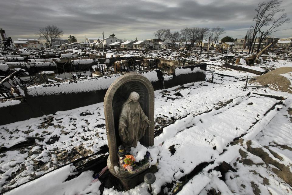 A religious statue stands in the fire-scorched landscape of Breezy Point after a Nor'easter snow, Thursday, Nov. 8, 2012 in New York.  The beachfront neighborhood was devastated during Superstorm Sandy when a fire pushed by the raging winds destroyed many homes.  (AP Photo/Mark Lennihan)