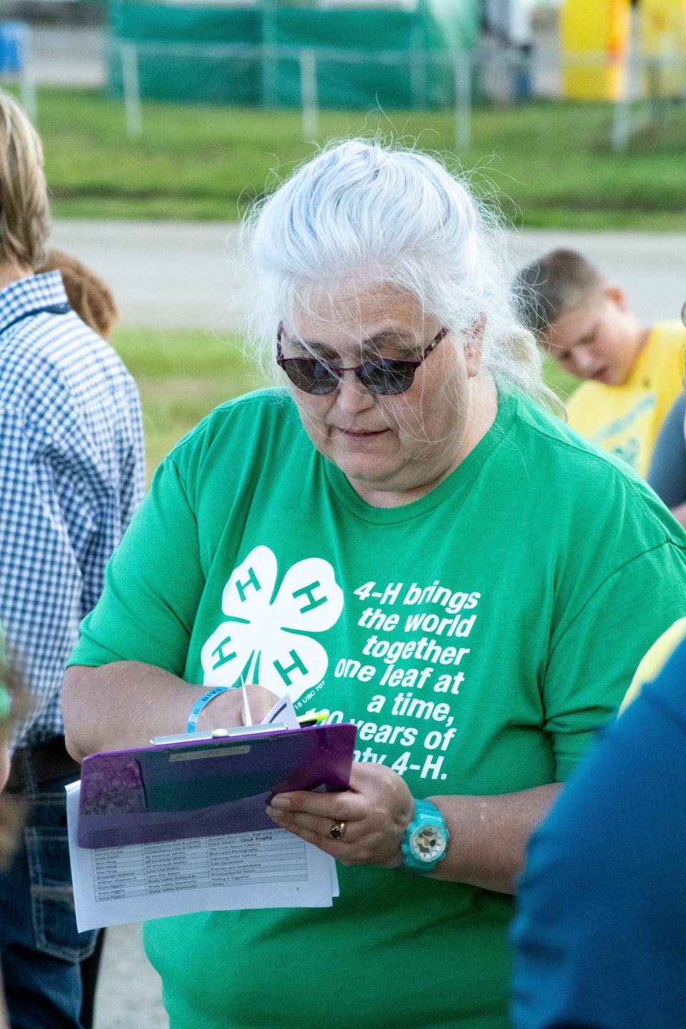 Judy Burnworth helps pass out 4-H awards during the 2022 Junior Fair awards presentation.