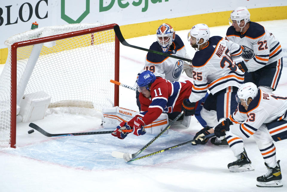 Montreal Canadiens' Brendan Gallagher (11) dives for a lose puck to score past Edmonton Oilers goaltender Mikko Koskinen during the first period of an NHL hockey game, Tuesday, March 30, 2021 in Montreal. (Paul Chiasson/The Canadian Press via AP)
