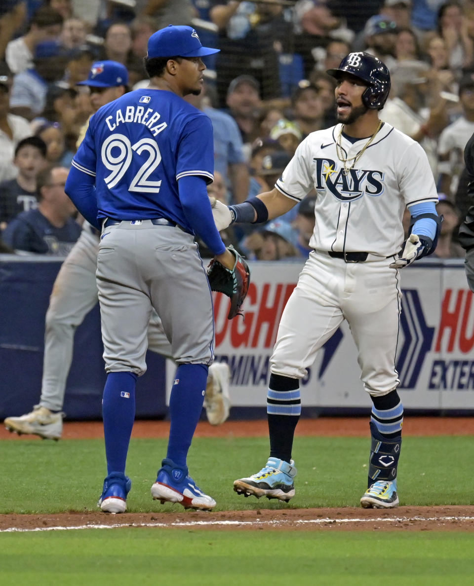 Tampa Bay Rays' Jose Caballero, right, confronts Toronto Blue Jays reliever Genesis Cabrera, left, after he was thrown out at third base during the seventh inning of a baseball game Saturday, March 30, 2024, in St. Petersburg, Fla. (AP Photo/Steve Nesius)