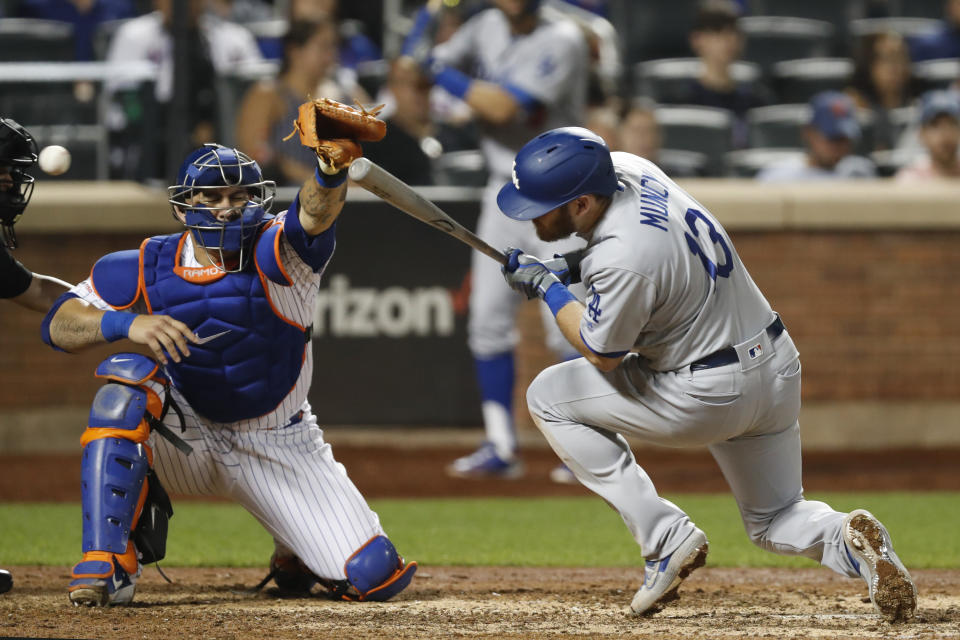 The ball whizzes past New York Mets catcher Wilson Ramos, left, as Los Angeles Dodgers' Max Muncy (13) ducks to avoid a high pitch in the eighth inning of a baseball game, Sunday, Sept. 15, 2019, in New York. (AP Photo/Kathy Willens)