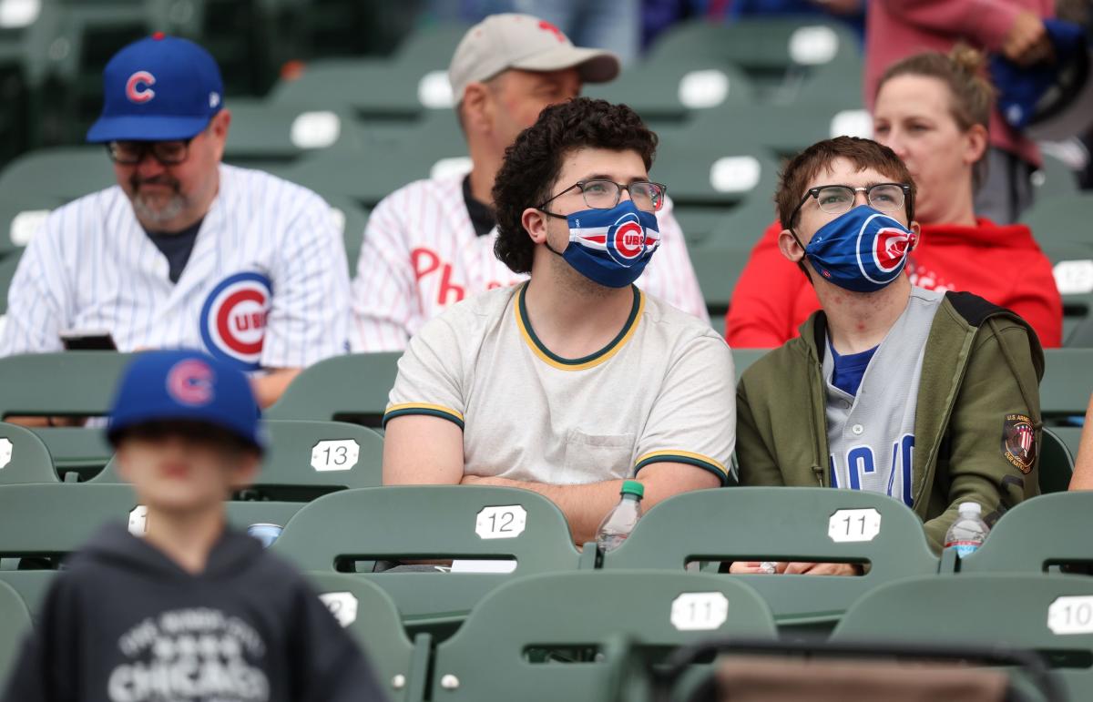 Cubs fan behind one-liner shirts