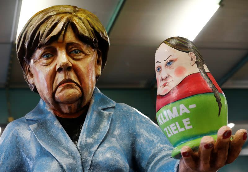 Papier mache figures for carnival floats depicting Germany's Chancellor Angela Merkel and a matryoshka, depicting Swedish environmental activist Greta Thunberg, are pictured during preparations for the upcoming Rose Monday carnival parade in Mainz