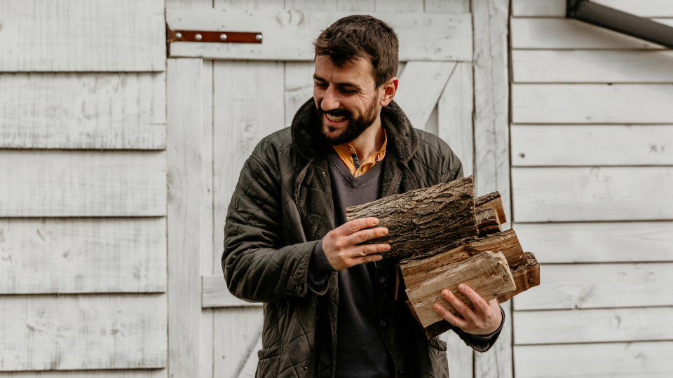 how to store firewood: man with firewood stack