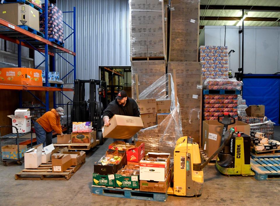 Sue Meyer (left), a volunteer at the Food Bank of West Central Texas and John McKenna, one of the nonprofit’s employees, sort food onto pallets in the warehouse Feb. 17.