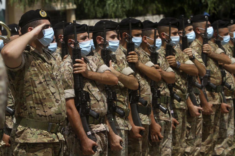 Lebanese army soldiers salut during the funeral procession of lieutenant Ayman Noureddine, who was killed by Tuesday's explosion that hit the seaport of Beirut, in Numeiriyeh village, south Lebanon, Friday, Aug. 7, 2020. Rescue teams were still searching the rubble of Beirut's port for bodies on Friday, nearly three days after a massive explosion sent a wave of destruction through Lebanon's capital. (AP Photo/Mohammed Zaatari)