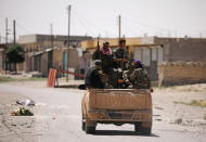 <p>Syrian Democratic Forces (SDF) fighters ride on a pick-up truck along a street in Raqqa’s western neighbourhood of Jazra, Syria June 11, 2017. (Photo: Rodi Said/Reuters) </p>