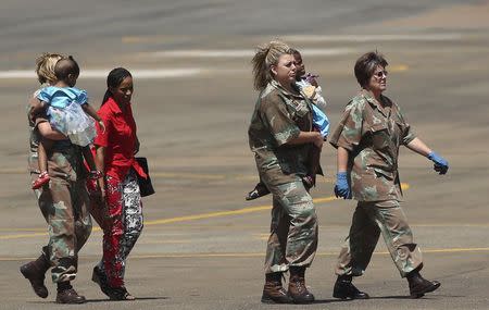 Members of the South African Army carry two children, who sustained injuries in a collapsed church guesthouse in Lagos and were evacuated from Nigeria, as they arrive at an air force base north of Johannesburg September 22 2014. REUTERS/Siphiwe Sibeko