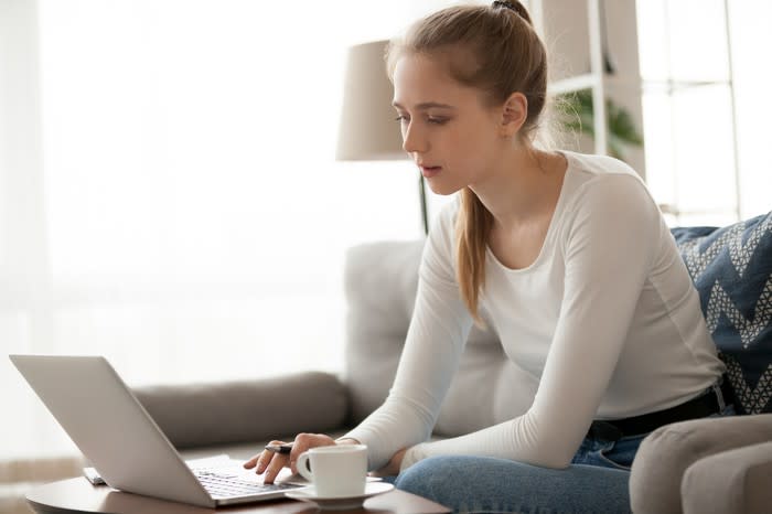 A young woman typing on a laptop