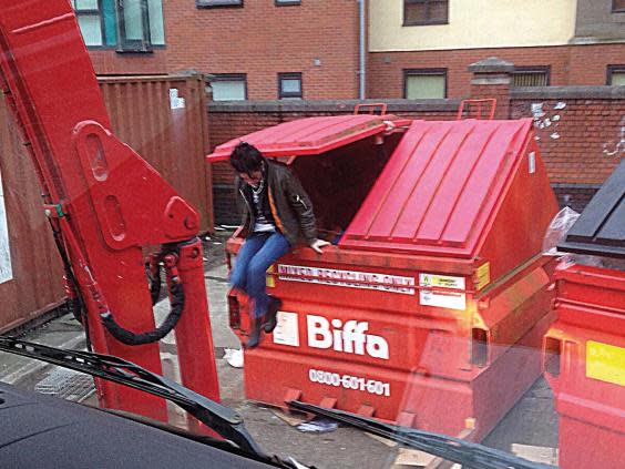 A rough sleeper emerges from a waste unit (Biffa)