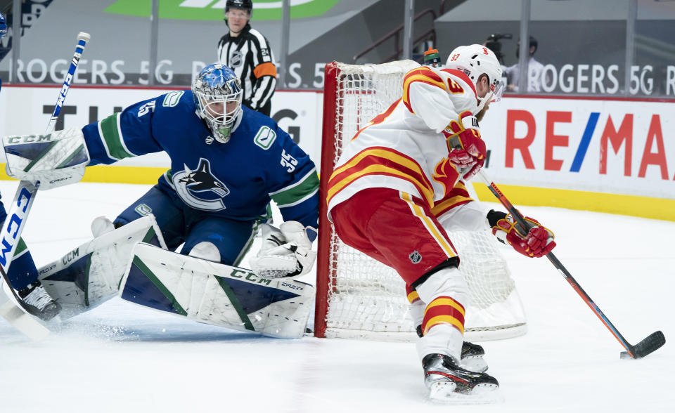 Calgary Flames center Sam Bennett (93) tries to get a shot past Vancouver Canucks goaltender Thatcher Demko (35) during the first period of an NHL hockey game Thursday, Feb. 11, 2021, in Vancouver, British Columbia. (Jonathan Hayward/The Canadian Press via AP)