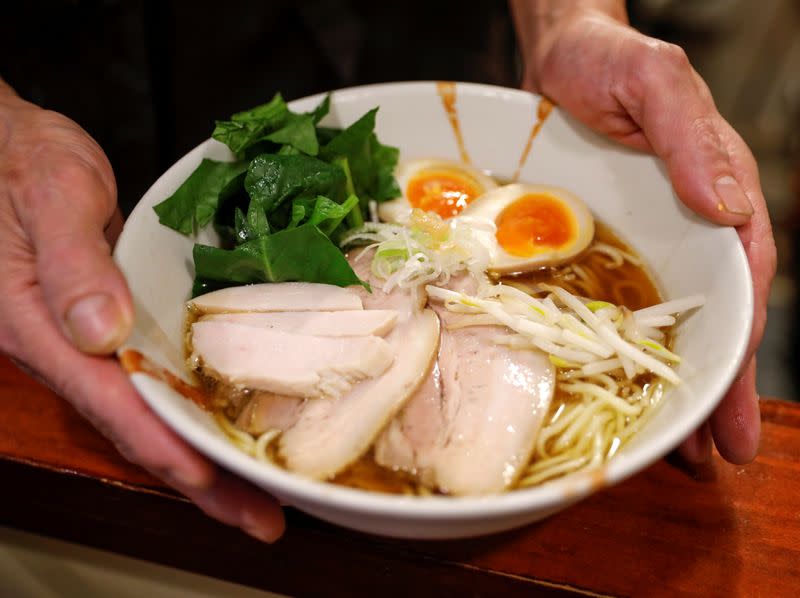 Sixty-year-old Yashiro Haga serves ramen at his noodle shop 'Shirohachi', amid the coronavirus disease (COVID-19) outbreak, in Tokyo