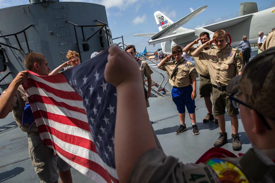 Boy Scouts Troop 494 retires flags in a fire pit on the the USS Lexington Museum on the Bay's deck on Memorial Day, May 30, 2022.