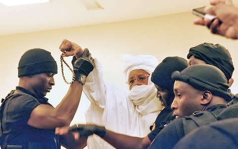 Habré is escorted into court - Credit: Getty Images