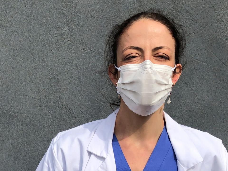 In this photo taken on Tuesday, April 7, 2020, Aurelie Gouel, an ICU doctor, poses during a break in her shift treating COVID-19 patients at Bichat Hospital in Paris. Gouel was infected by the new coronavirus in March but rushed back to work as soon as she recovered from her high fever, cough and other symptoms because she felt compelled to rejoin the fight to save lives.  The coronavirus has infected so many doctors, nurses and other health workers that some are now returning to work hoping that they are now armed with some degree of immunity. (AP Photo/John Leicester)