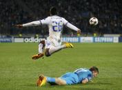 Zenit St Petersburg's Oleg Shatov (bottom) lies on the pitch as Porto's Alex Sandro jumps above during their Champions League soccer match at the Petrovsky stadium in St. Petersburg November 6, 2013. REUTERS/Alexander Demianchuk (RUSSIA - Tags: SPORT SOCCER)