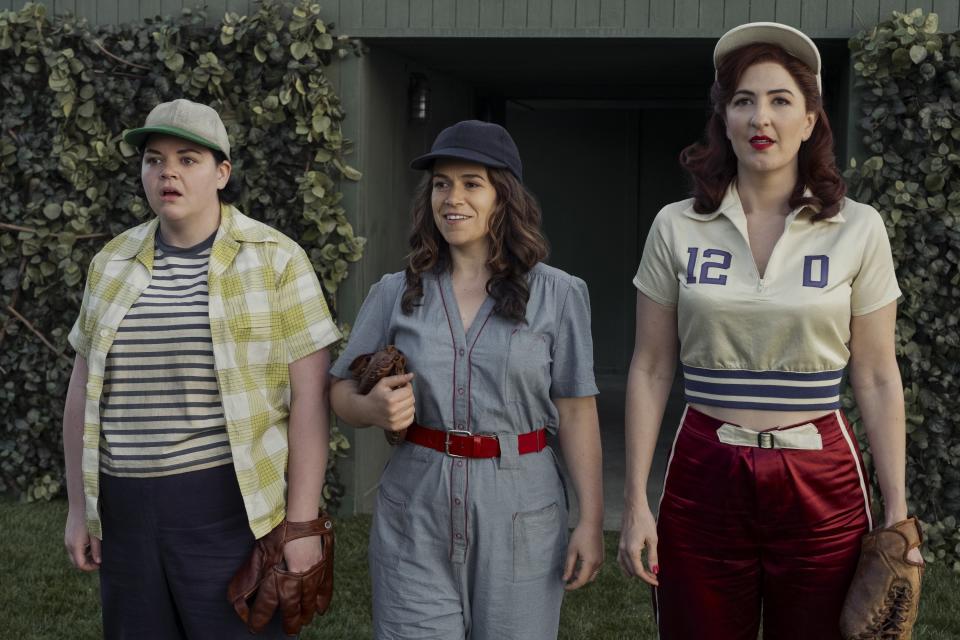 Melanie Field, Abbi Jacobson, and D'Arcy Carden stand outside wearing 1940s baseball/workout clothes in A League of Their Own.