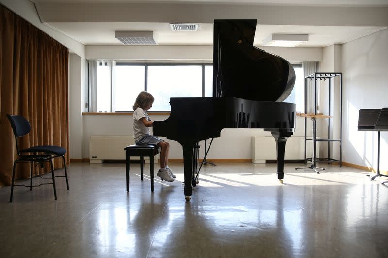 Stelios Kerasidis, 7-year-old pianist and composer, plays the piano during a lesson at the Athens Megaron Concert Hall in Athens