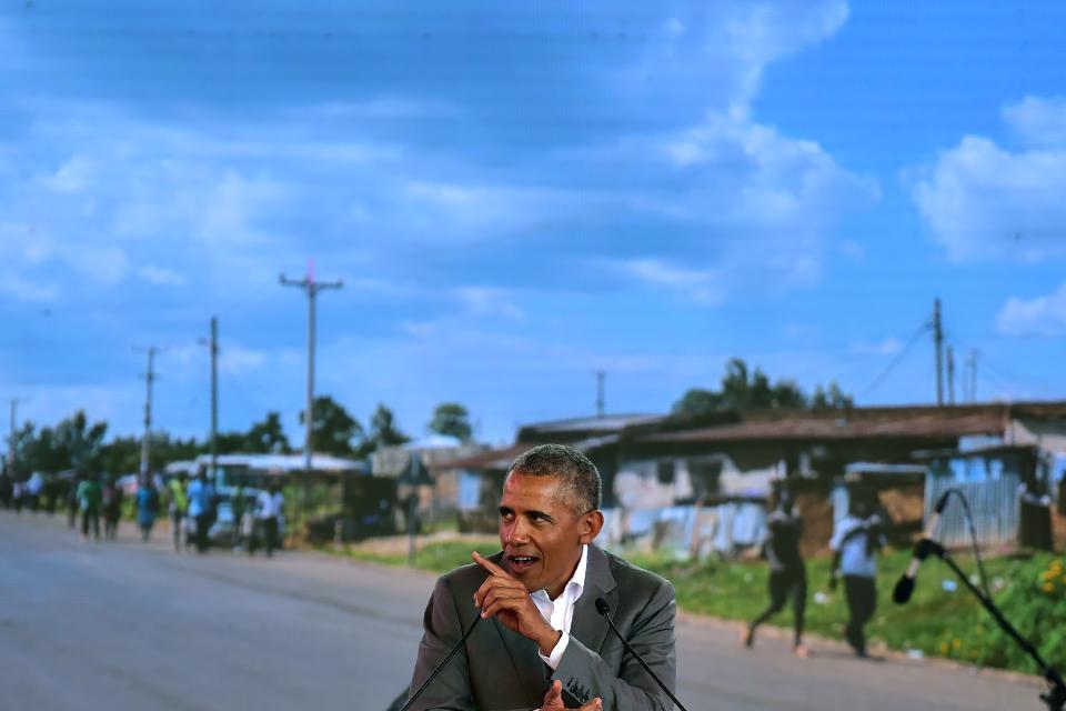 <p>Former US President, Barack Obama gestures as he makes an address on July 16, 2018 in front of a projected backdrop showing a view of his father’s home village, the hamlet of Nyang’oma in Kogelo, during the opening of the Sauti Kuu Resource Centre founded by his half-sister, at Kogelo in Siaya county, western Kenya. – Obama is in the east african nation for the first time since he left the US presidency and met with President Uhuru Kenyatta and opposition leader Raila Odinga in Nairobi. (Photo: Tony Karumba/AFP/Getty Images) </p>