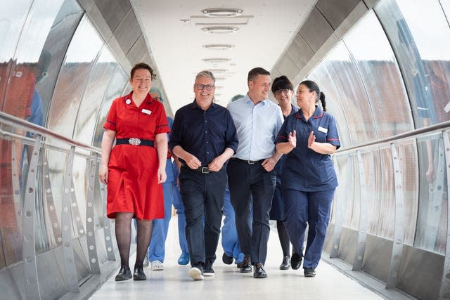 Sir Keir Starmer and Wes Streeting walking through a hospital corridor with nurses