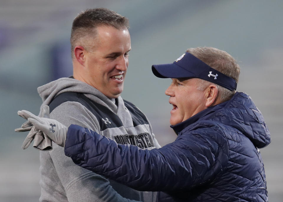 Northwestern's coach Pat Fitzgerald, left, speaks with Notre Dame's coach Brian Kelly before the start of an NCAA college football game Saturday, Nov. 3, 2018, in Evanston, Ill. (AP Photo/Jim Young)
