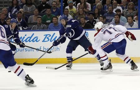 May 6, 2015; Tampa, FL, USA; Tampa Bay Lightning center Tyler Johnson (9) passes the puck as Montreal Canadiens defenseman Tom Gilbert (77) defends during the second period of game three of the second round of the 2015 Stanley Cup Playoffs at Amalie Arena. Mandatory Credit: Kim Klement-USA TODAY Sports