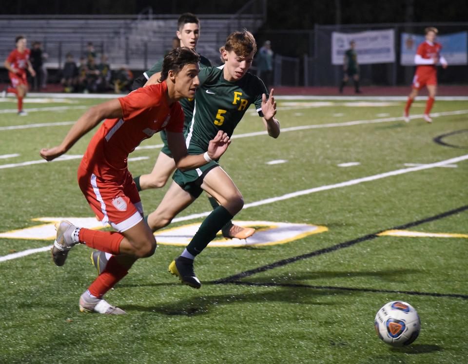 Issac Miles of Grosse Ile controls the ball being chased down by Laran Rogier of Flat Rock in the district semifinals at Flat Rock Tuesday, October 17, 2023.