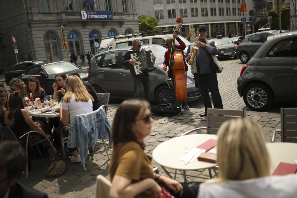 Romanian musicians perform for money in a restaurant area near the European Parliament at the European quarter in Brussels, Thursday, May 23, 2019. Dutch and British voters were the first to have their say Thursday in elections for the European Parliament, starting four days of voting across the 28-nation bloc that pits supporters of deeper integration against populist euroskeptics who want more power for their national governments. (AP Photo/Francisco Seco)
