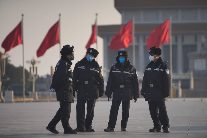 Police officers wearing masks are seen at at the Tiananmen Square, as the country is hit by an epidemic of the new coronavirus, in Beijing