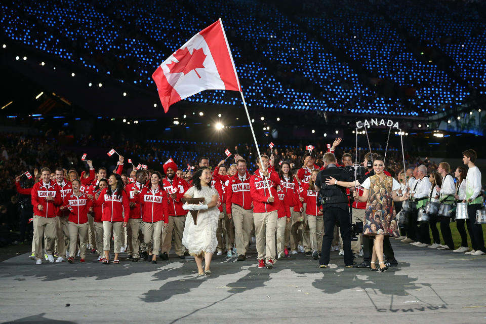 LONDON, ENGLAND - JULY 27: Simon Whitfield of the Canada Olympic triathlon team carries his country's flag during the Opening Ceremony of the London 2012 Olympic Games at the Olympic Stadium on July 27, 2012 in London, England. (Photo by Cameron Spencer/Getty Images)