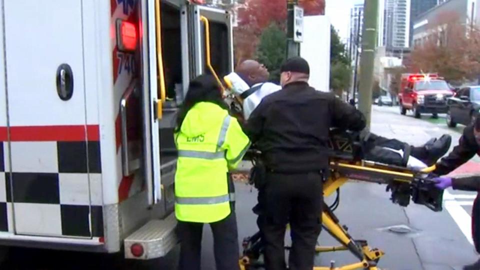 PHOTO: A security guard is placed in an ambulance after being injured when a protester set themselves on fire in an apparent 'political protest' outside an Israeli Consulate office in Atlanta, Dec. 1, 2023. (WSB)