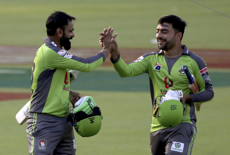 Lahore Qalandars Rashid Khan, right, and Mohammad Hafeez congratulate each other after taking winning run during a Pakistan Super League T20 cricket match between Peshawar Zalmi and Lahore Qalandars at the National Stadium, in Karachi, Pakistan, Sunday, Feb. 21 2021. (AP Photo/Fareed Khan)