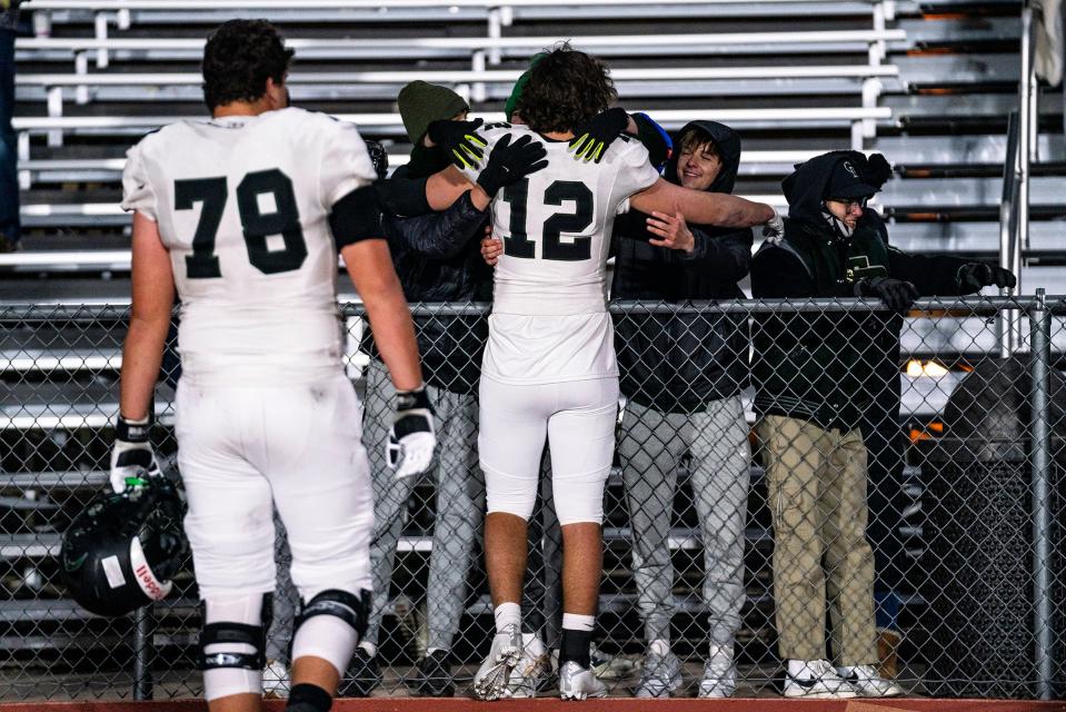 Fossil Ridge's Mac Busteed (12) embraces SaberCat fans after a Class 5A football playoff game vs. Regis Jesuit in Aurora, Colo. on Friday, Nov. 11, 2022.