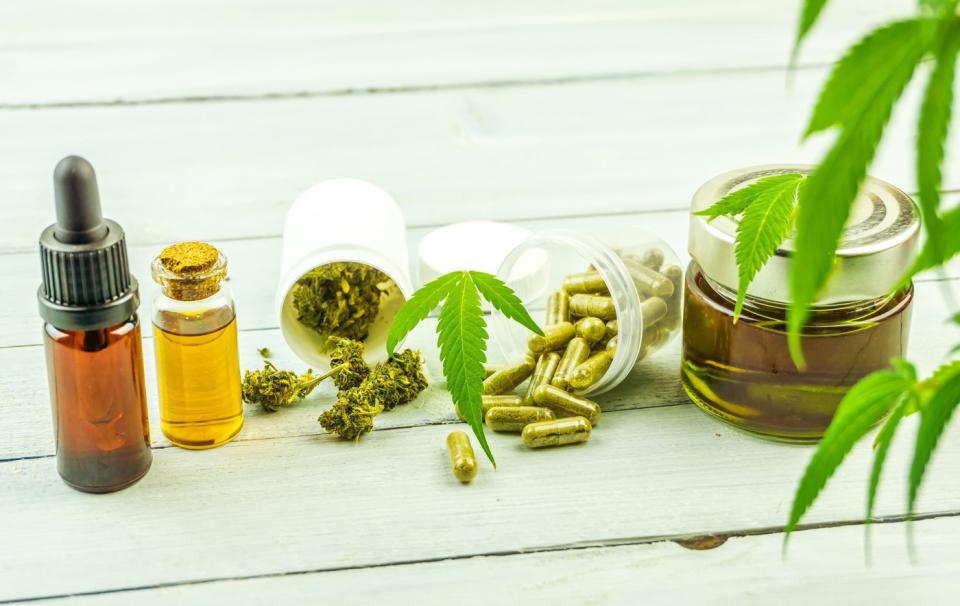 Cannabis buds, pills, and oil on a table