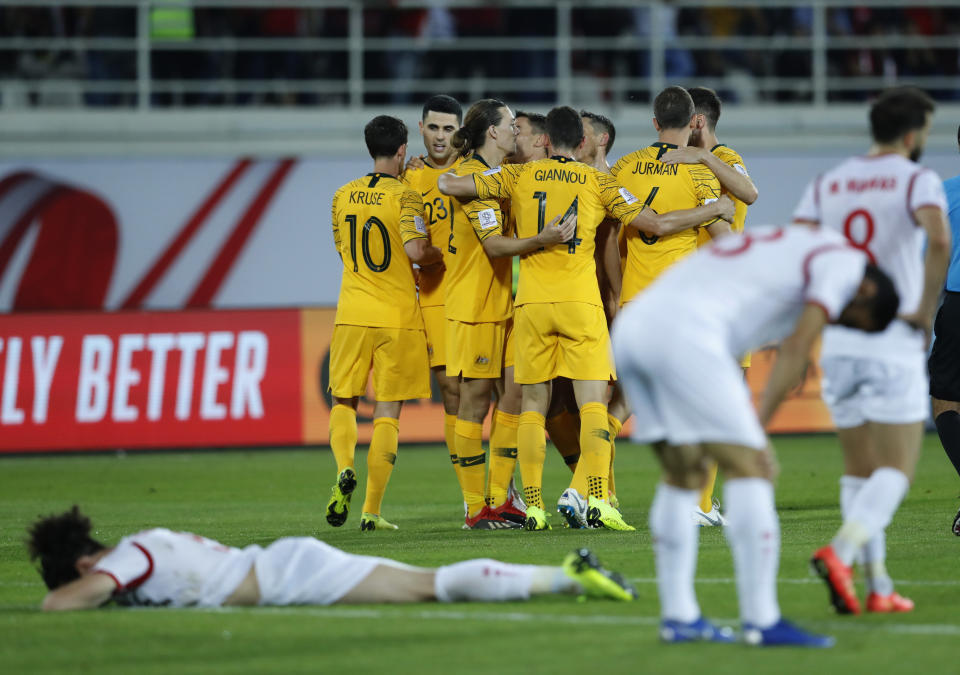 Australian players, background, celebrate in the end of the AFC Asian Cup group B soccer match between Australia and Syria at the Khalifa bin Zayed Stadium in Al Ain, United Arab Emirates, Tuesday, Jan. 15, 2019. (AP Photo/Hassan Ammar)