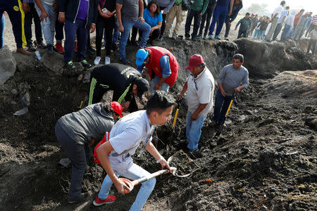 Residents search for human remains and items that could help to identify their missing relatives and friends at the site where a pipeline ruptured by oil thieves exploded, in the municipality of Tlahuelilpan, state of Hidalgo, Mexico January 20, 2019. REUTERS/Henry Romero
