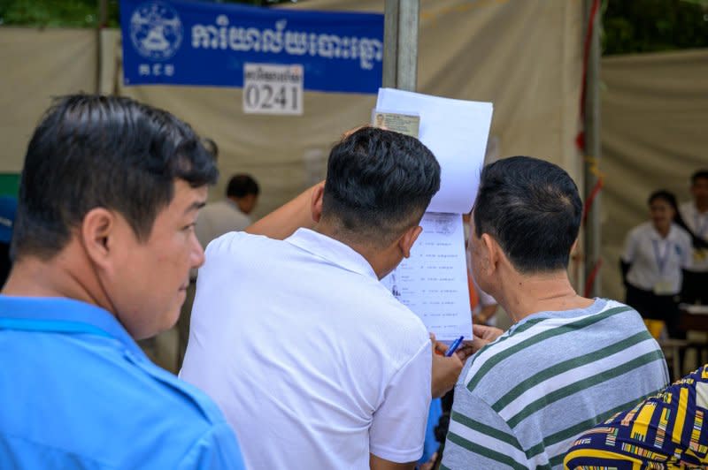 Voters check their names on a list at a polling station Sunday. Photo by Thomas Maresca/UPI