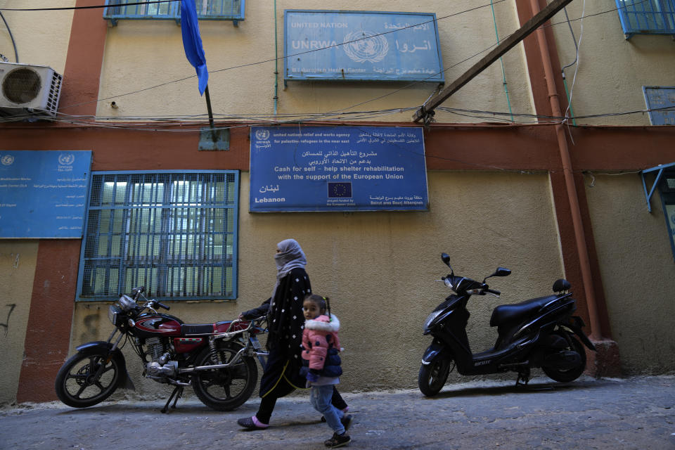 FILE - A Palestinian woman and her daughter pass in front and office of the agency for Palestinian refugees, UNWRA, in the Bourj al-Barajneh Palestinian refugee camp, in Beirut, Lebanon, Tuesday, Jan. 18, 2022. United Nations Relief and Works Agency UNRWA Commissioner-General Philippe Lazzarini warned on Thursday, April 6, 2023, that it faced growing challenges in running its operations as donors were set to contribute less money this year. (AP Photo/Hussein Malla, File)