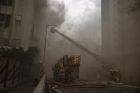 Firefighters battle a fire in Cheung Sha Wan, a residential and industrial area, in Hong Kong, Friday, March 24, 2023. (AP Photo/Louise Delmotte)