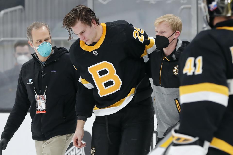 FILE - Boston Bruins' Brandon Carlo is helped off the ice during the first period of an NHL hockey game against the Washington Capitals in Boston, in this Friday, March 5, 2021, file photo. The Boston Bruins and Washington Capitals already have bad blood built up going into their first-round playoff series that starts Saturday night, May 15. (AP Photo/Michael Dwyer, File)