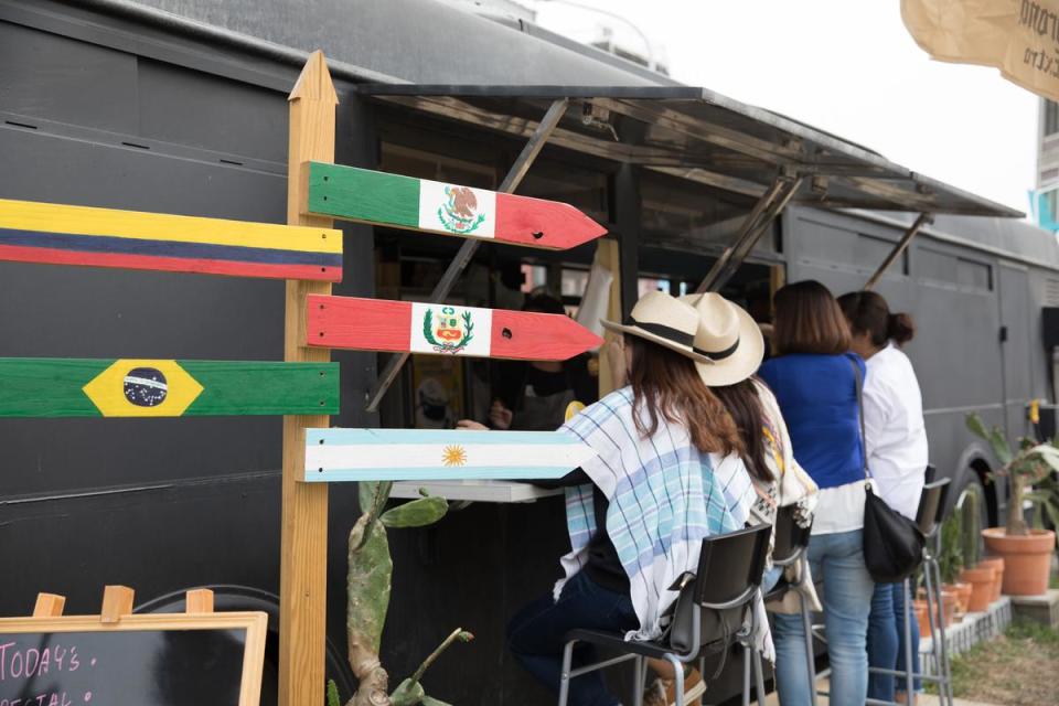 老巴士駛向南美洲，路牌標示哥倫比亞、阿根廷、秘魯、巴西等各國。
