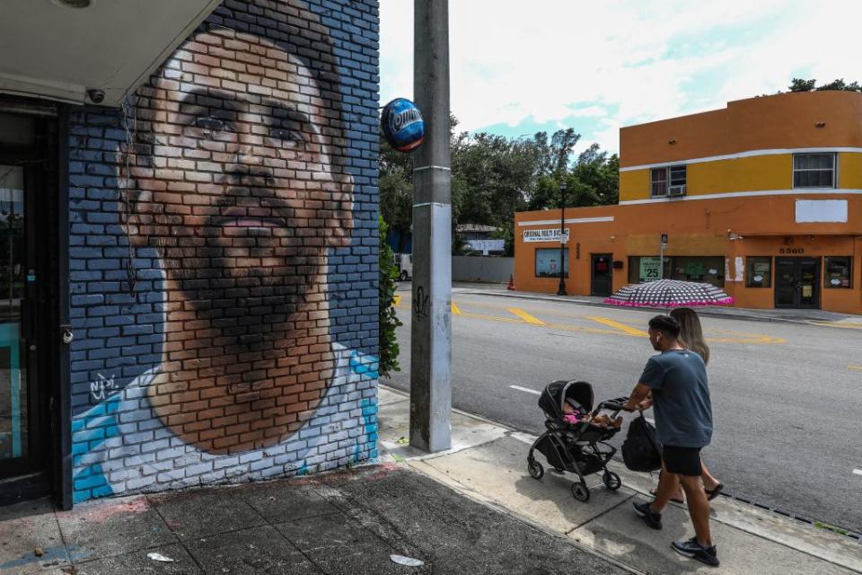 La gente camina frente a un mural de Lionel Messi en Miami, el 7 de junio de 2023. (Crédito: GIORGIO VIERA/AFP via Getty Images)